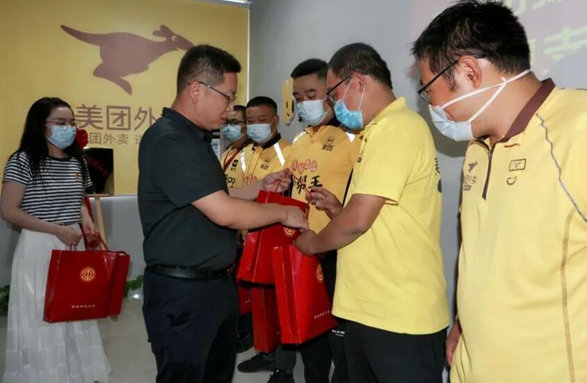 市总工会党组成员、副主席王建华为外卖骑手代表发放“夏季送清凉”大礼包。