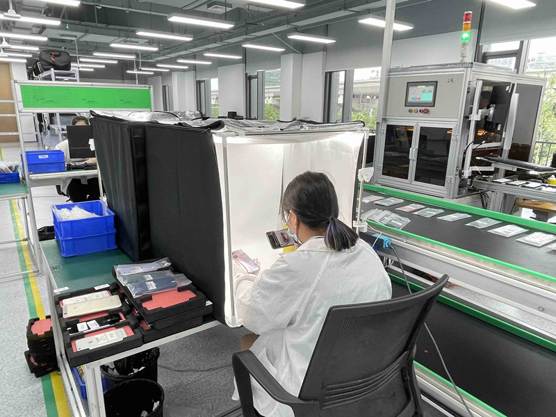 质检工程师在检测手机外观。记者 陈蔚 摄