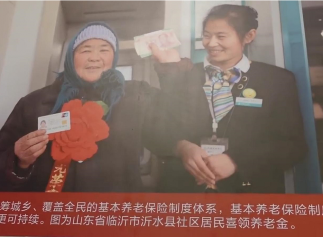 图为临沂市沂水县社区居民喜领养老金。