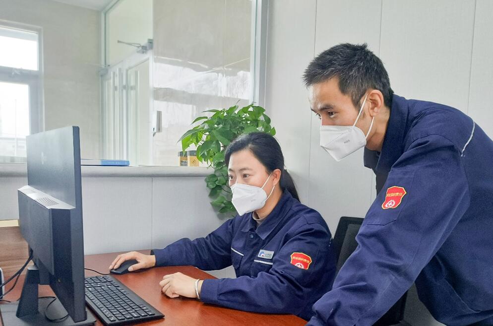 图为杨福兴与同事交流系统运行中的问题