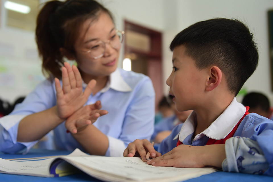 一小学学生在老师的指导下完成课后作业。（新华社记者 王民/图）