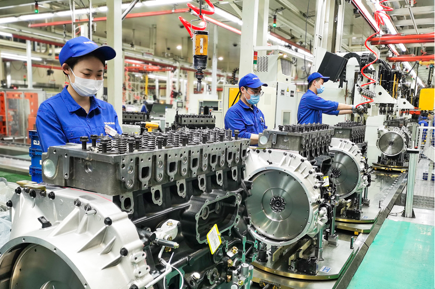 位于潍坊的潍柴集团生产车间，工人在流水线上装配发动机。（□资料图）