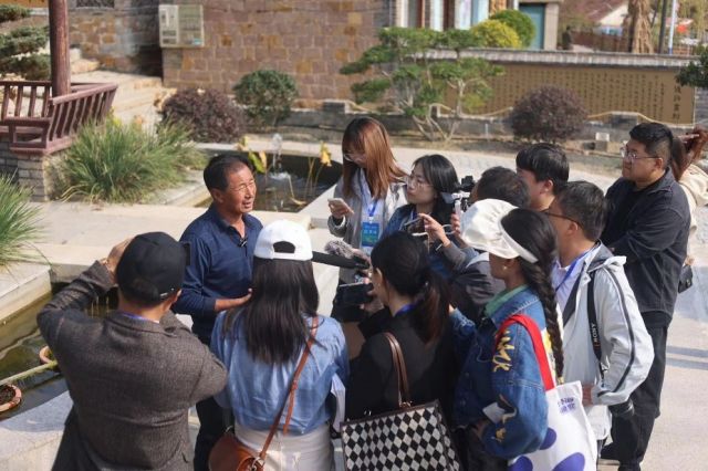 栖霞市庙后镇后许家村村委副主任王义喜向记者们介绍民宿