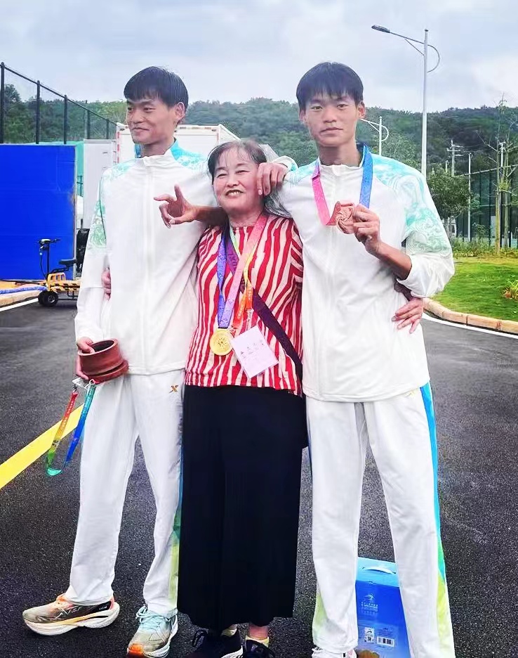 弟弟李武和母亲、哥哥李文合影，手拿铜牌的是哥哥李文。