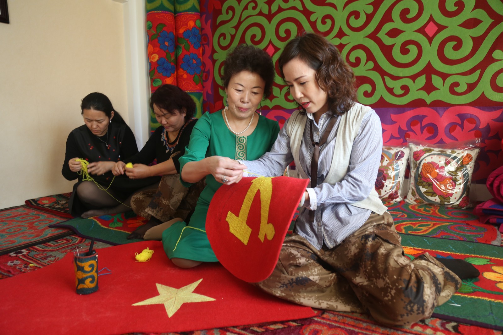 2017年12月19日，一〇四团机关干部王玉凤（右一）和哈萨克亲戚乌木提汗在家中共同绣出了党徽、党旗。（高迪 摄）