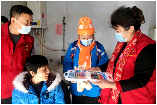 在海丰街道汪家村杜燕(右二)家中，志愿者给她送来温暖的冬衣和绘图彩笔等文具。