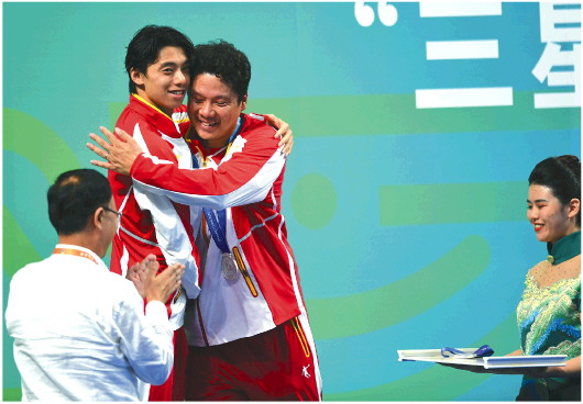 9月21日，已获得一枚金牌的季新杰又收获了200米自由泳的银牌。 颁奖台上，他与教练金浩拥抱在一起。□记者 李勇 报道 