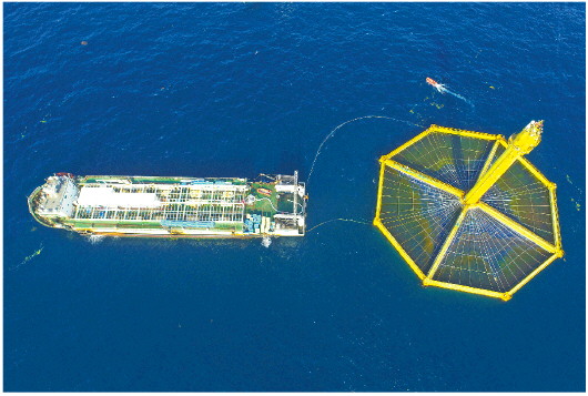 国家深远海绿色养殖试验区内，全潜式深远海养殖网箱深蓝1号和养殖工作船正在作业。（□记者 肖芳 报道）