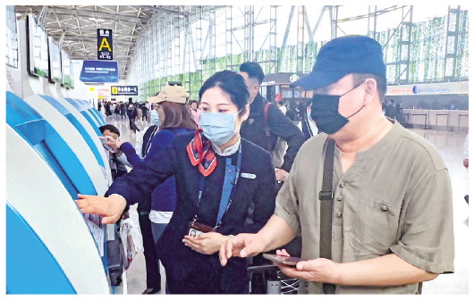 □記者常青通訊員王淑慧報道 4月28日，濟南機場，旅客在工作人員引導下取票。