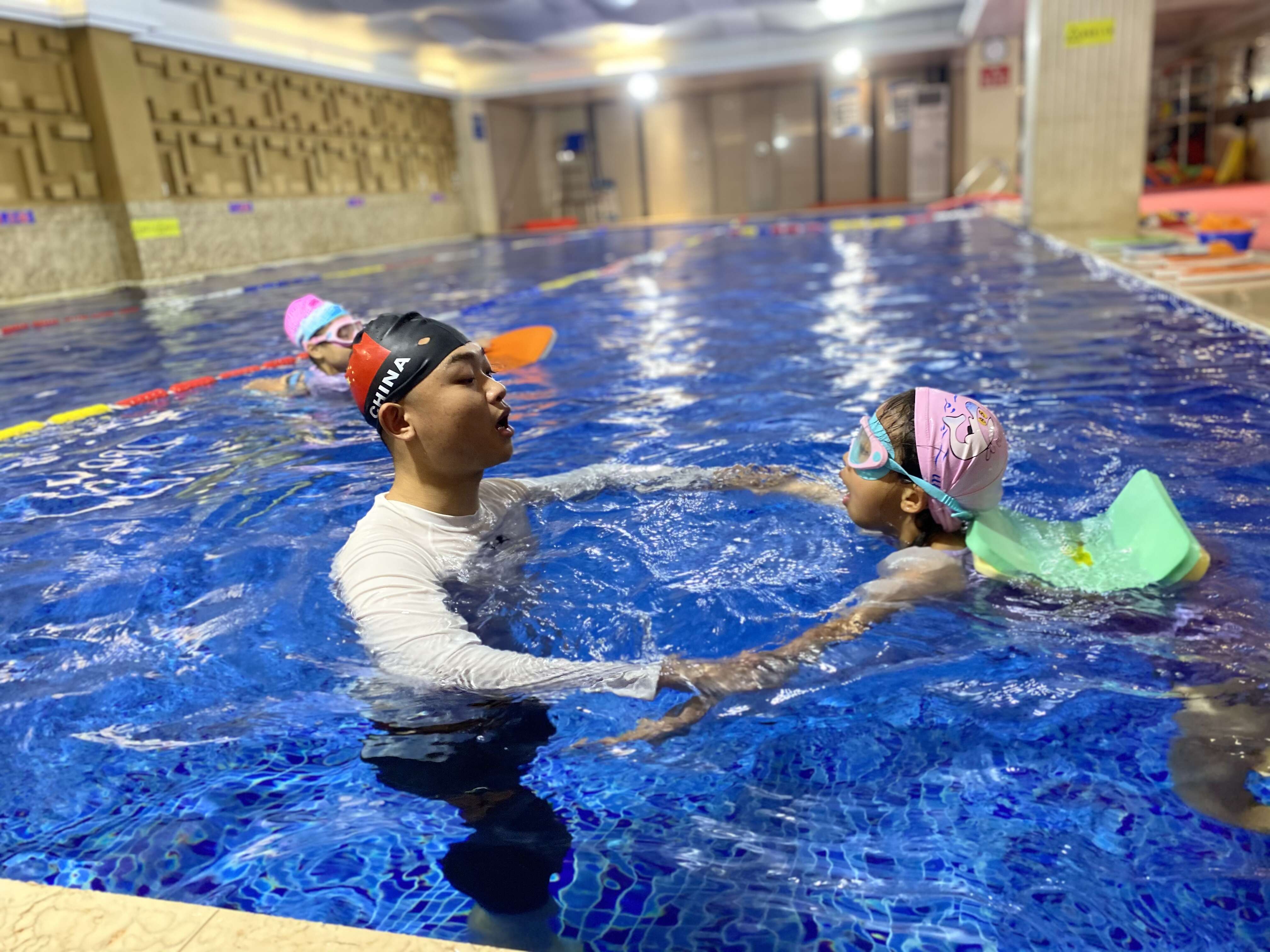 创办的儿童预防溺水培训基地内,教练员正在对学生进行游泳技巧指导