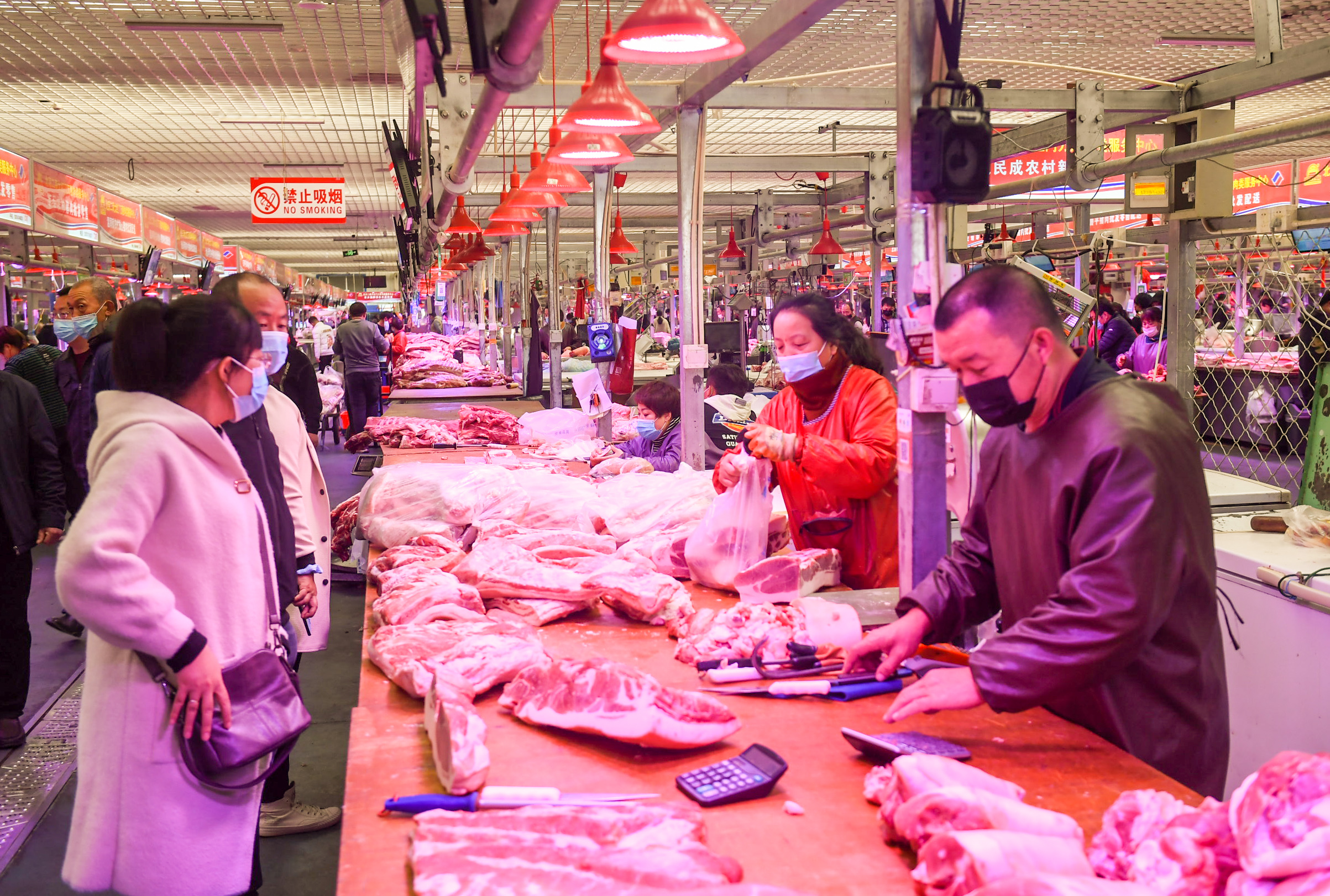 10月24日,在内蒙古呼和浩特市万惠农贸批发市场,市民在采购猪肉